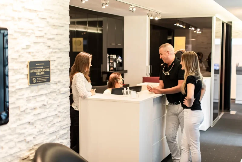 Das Glam-Smile-Team im Gespräch mit Patientinnen am Empfang